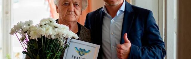 Правдиво ли это фото украинского чиновника и матери погибшего солдата, которую наградили грамотой „за воспитание героя“?