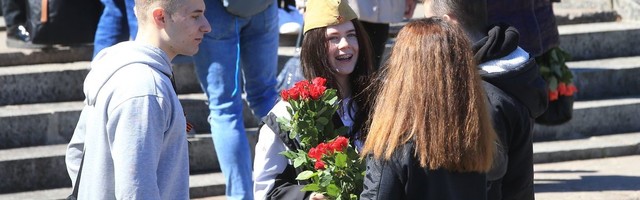 Люди выстраиваются в очередь, чтобы возложить цветы к монументу в Тарту
